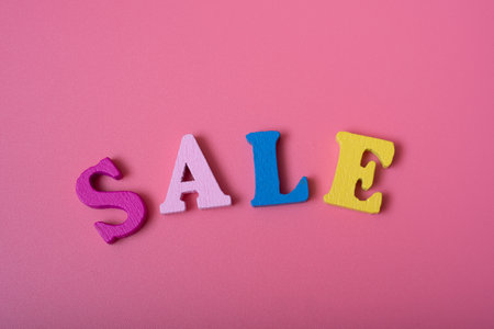 The word sale on a pink background of multicolored letters. concept of sales and discounts.の写真素材