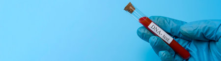 A hand holds a DNA test in a test tube on a blue background. Place under the text. The concept of...