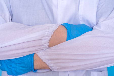 Cropped closeup photo of professional doctor in gloves standing with folded crossed arms. The concept of medicine and rehabilitation.の写真素材