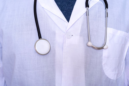 Close-up of a male doctor wearing a white medical coat and a stethoscope with a T-shirt. The concept of medicine and healthcare.の写真素材