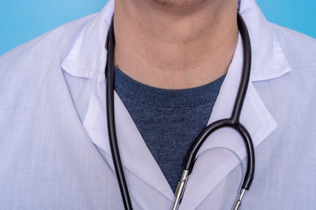 Close-up of a male doctor wearing a white medical coat and a stethoscope with a T-shirt. The concept of medicine and healthcare.の写真素材