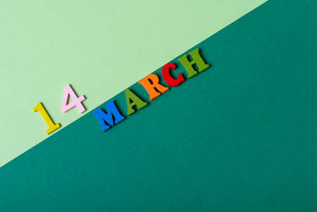 March 14, Date cover design with wooden, multicolored K letters on a green paper background. Background on the eve of St. Patrick's Day.の写真素材