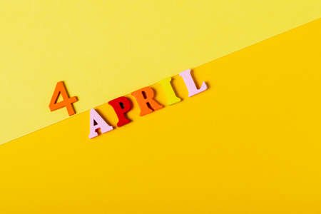 Wooden letters of the fourth of April on a yellow background. Qing Ming Festival.の写真素材