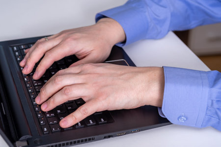 Closeup of a worker using a laptop computer. The concept of working on a laptop.