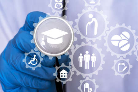 A hand in a medical glove pulls a medical mask from under a stethoscope, Medicine icons. the concept of having to wear a medical mask.の写真素材