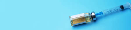 Medical bottle with syringe on blue background. Laboratory of medical preparations. Place under the text.の写真素材