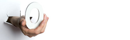 Female hand holding a number zero white isolated background. Copy Space.の写真素材