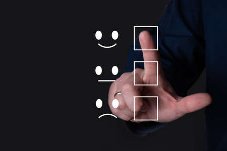 The finger presses the icon with a cheerful smile. The concept of a good choice.の写真素材