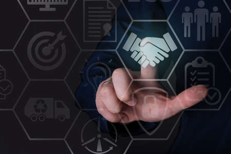 The businessman clicks on the handshake icon. The concept of the contract and agreement.の写真素材