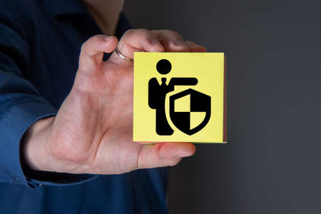 A businessman with a protective gesture and badges of human life insurance. The concept of insurance.の写真素材