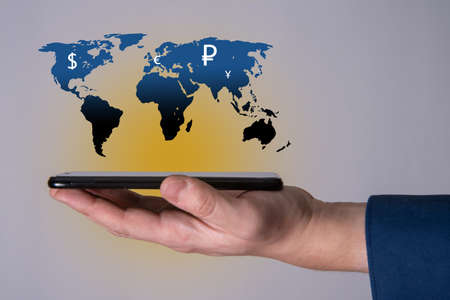 The phone and the map of the planet earth as an icon with currency signs of different countries of the world. The concept of the development of the world and Europe in order to save.の写真素材