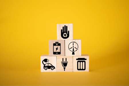 Ecology concept with icons on wooden cubes, yellow background. The concept of clean energy for the...