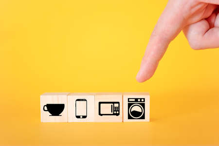 Icons of household appliances on wooden cubes, yellow background. The concept of household appliances for life.の写真素材