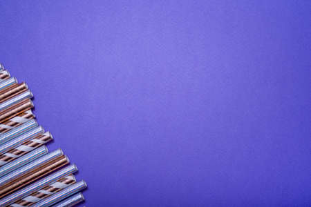 A set of colorful straws for drinks on a lilac background. Close-up. Festive birthday concept.の写真素材