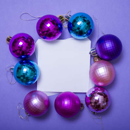 Christmas toys and a Christmas tree with a sheet of paper on a lilac background. The concept of a holiday and a new year.の写真素材