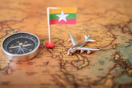 Myanmar flag, airplane and compass on the world map. The concept of travel and tourism.の写真素材