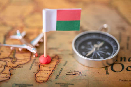 Flag of Madagascar, compass and airplane on the world map. The concept of tourism and recreation.の写真素材