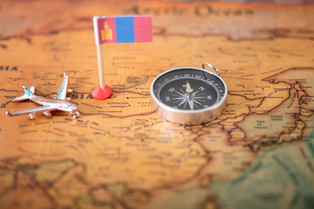 Flag of Mongolia, airplane and compass on the world map. The concept of travel and tourism.の写真素材