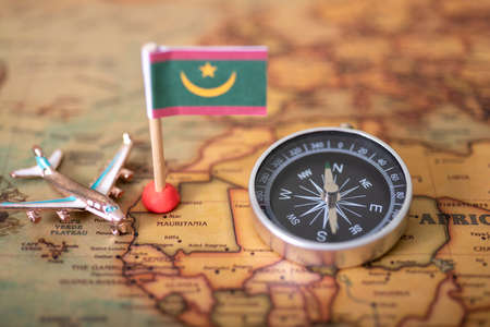 Flag of Mauritania, compass and airplane on the world map. The concept of travel and tourism.の写真素材