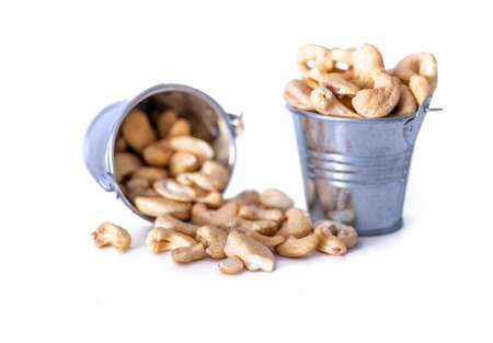 Nuts in metal bucket isolated on white background. The concept of healthy food.の写真素材