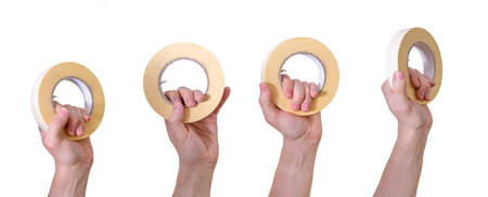 Painter's tape in the hands of a man against a white background. labor day. The concept of May 1, work with his hands.の写真素材