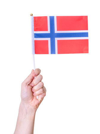 A hand holds the flag of Norway on a white isolated background. The concept of a great country.の写真素材
