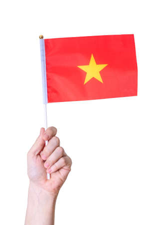 A hand holds the flag of Vietnam against a white isolated background. The concept of a great country.の写真素材