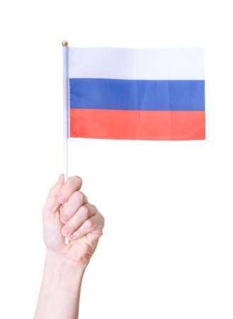 The hand holds the flag of Russia on a white insulated background. The concept of a great country.の写真素材