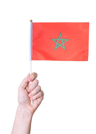 A hand holds the flag The flag of Morocco on a white isolated background. The concept of a great country.の写真素材