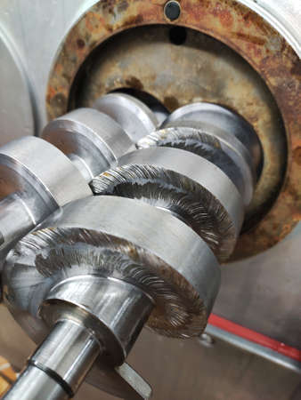 The feed screw for the meat grinder is sticking out of the machine. Meat production concept.の写真素材