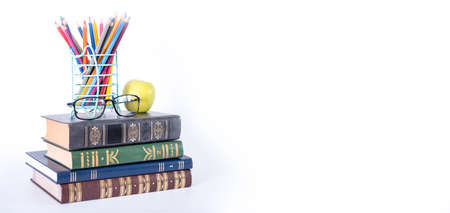 A stack of books, study guides, textbooks, glasses, and pencils in a text copy holder. Knowledge Day or International Literacy Day.の写真素材