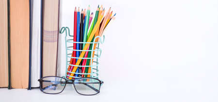 A stack of books, study guides, textbooks, glasses, and pencils in a text copy holder. Knowledge Day or International Literacy Day.の写真素材