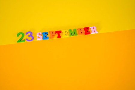 September 23 on a yellow and paper background with wooden letters and numbers in different colors. Eid al-Adha or Yom Kippur.の写真素材