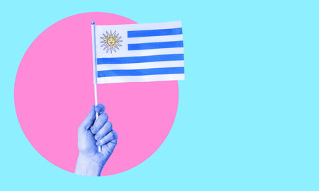 A collage of modern art. Female hand holding the flag of Uruguay in a circle, neon background, with space for text. Concept of tourism and travel.の写真素材