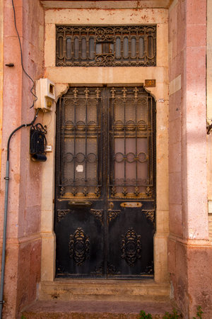 The front doors of a traditional Middle Eastern stone house. Metal doors decorated with copper-colored wrought metal on a street in a Middle Eastern town.の写真素材
