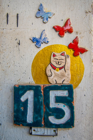 A sign with the number 15, butterflies, and a cat. Concept of design and construction.の写真素材