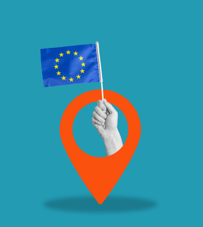 Art collage, collage of a hand holding the flag of the European Union, navigation icon on a blue background. Concept of the direction of the EU on a blue shabby background.の写真素材