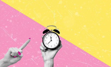 Human hand holding an alarm clock on a pink and yellow background, with copy space. Concept of idea and modern art.の写真素材