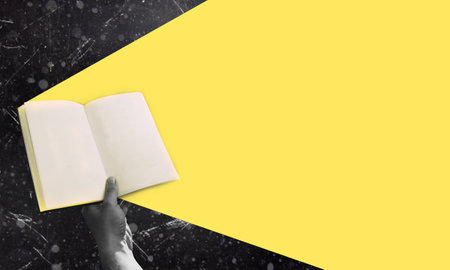 Art collage, book in hand on black background with copy space. The concept of education and learning.の写真素材