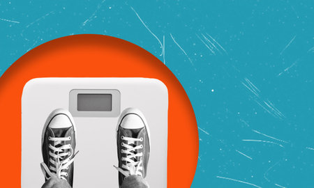 A person is weighing themselves on a digital scale, focusing on their weight as part of their daily health routine, with a colorful backdrop enhancing the moment.の写真素材