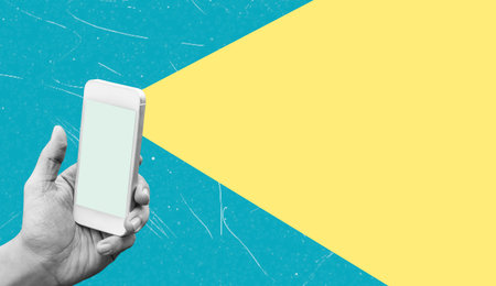 Art collage, A hand holds a smartphone that emits a bright beam of light against a contrasting blue...