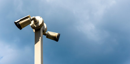 A security camera mounted on a tall pole captures footage of the sky. The camera is positioned to...