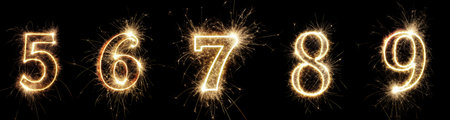Bright sparkling numbers from 5 to 9 light up the darkness, capturing the excitement of a countdown event. Fireworks enhance the festive atmosphere in this lively scene.の写真素材