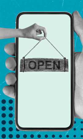 A hand lifts an 'Open' sign displayed on a smartphone's screen, symbolizing the launch of a business. The background is blue with abstract designs, creating a vibrant atmosphere.の写真素材