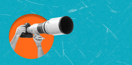 A person holds a large camera lens with a stabilizer, preparing to capture clear and focused images....