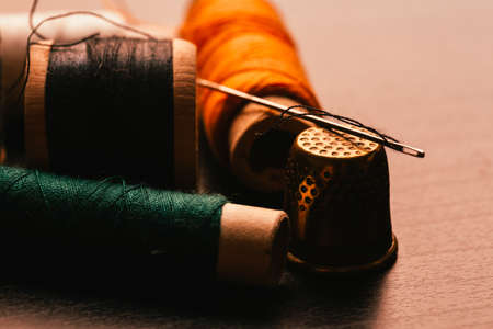 many Vintage spools of thread and a thimble on a wooden backgroundの写真素材