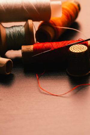 many Vintage spools of thread and a thimble on a wooden background