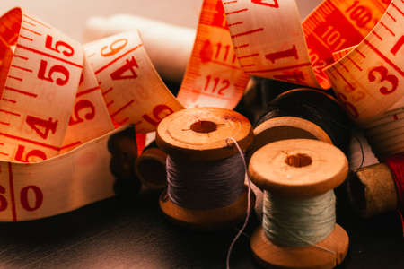 Vintage spools of thread thimble and measuring tape on a wooden backgroundの写真素材