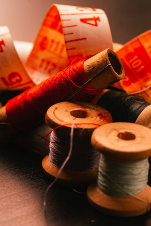 Vintage spools of thread thimble and measuring tape on a wooden background