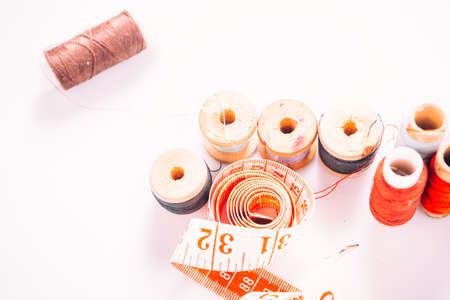tailor the tool to measure the length,  spools of colored thread on a wooden backgroundの写真素材